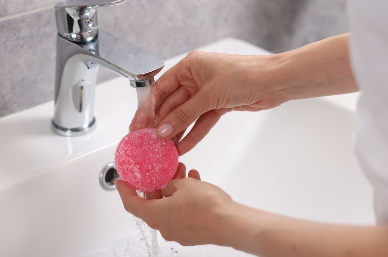 cô gái đang rửa mặt với bông rửa mặt