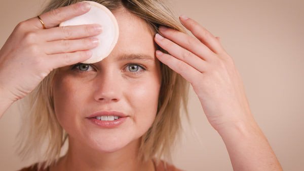Cô gái đang tỉ mỉ tẩy trang vùng mắt bằng bông tẩy trang và dung dịch micellar