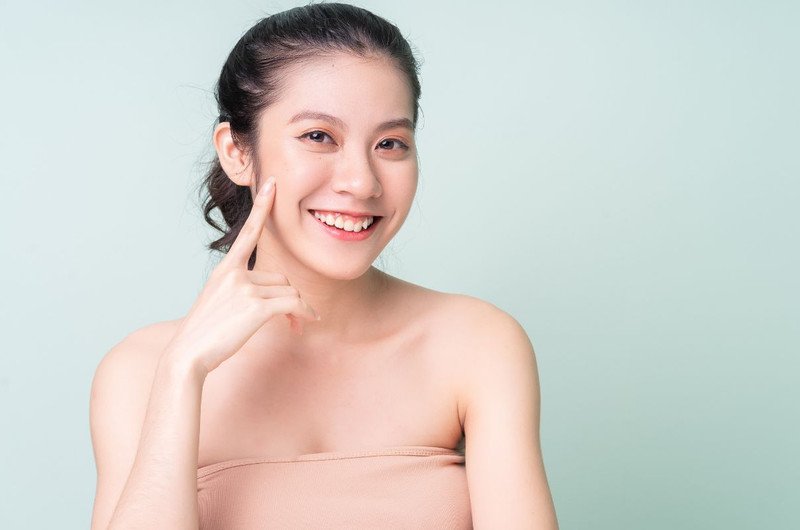 Cô gái trẻ rạng rỡ với làn da ẩm mượt sau khi sử dụng mặt nạ ngủ, biểu trưng cho lợi ích dưỡng da
