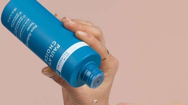 Hình ảnh chai toner chứa Niacinamide đặt cạnh các sản phẩm chăm sóc da khác, tượng trưng cho bước cấp ẩm và cân bằng cho da dầu mụn
