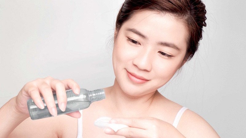 Hình ảnh một người phụ nữ đang nhẹ nhàng thoa toner lên da mặt sau khi xông hơi để se khít lỗ chân lông và cấp ẩm