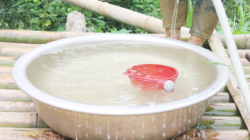 Hình ảnh nước nhiễm phèn có màu vàng đục và váng nổi, biểu hiện của nguồn nước kém chất lượng gây hại cho sức khỏe và sinh hoạt hàng ngày.
