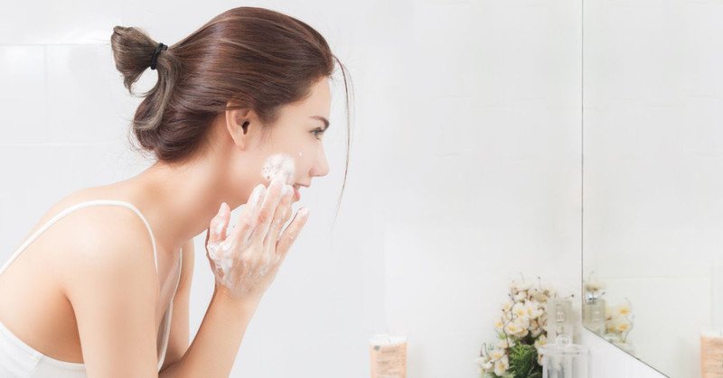 Một người đang rửa mặt với sữa rửa mặt dịu nhẹ, bước quan trọng để làm sạch da trước khi áp dụng các sản phẩm chăm sóc da khác.