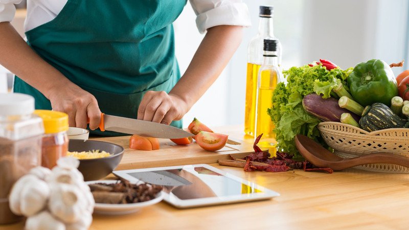 Người phụ nữ đang cắt rau chuẩn bị nấu ăn lành mạnh để giảm cân