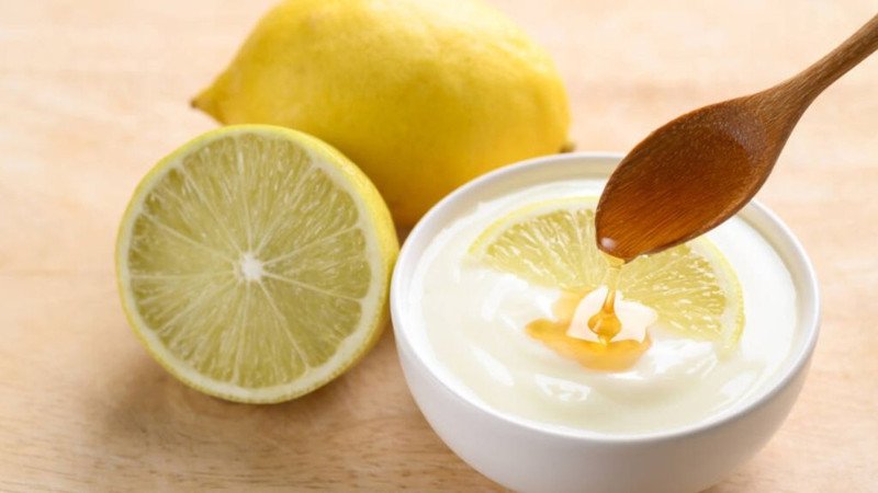 Người phụ nữ đang thoa hỗn hợp mặt nạ sữa chua và chanh lên vùng da có mụn đầu đen trên mũi