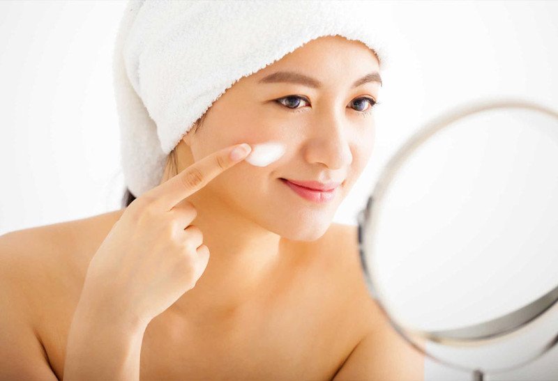 Người phụ nữ sử dụng kem dưỡng ẩm sau khi đắp mặt nạ nhau thai cừu