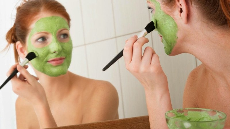 Phụ nữ trẻ đang chuẩn bị đắp mặt nạ bột tại nhà để làm đẹp da